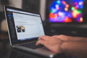 Zdjęcie osoby korzystającej z laptopa i przeglądającej internet.